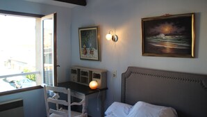 A bedroom with a bed, a desk, a chair, a window, and two wall-mounted lamps. - Chambres d'hôtes Elisa & Etienne (Manosque)