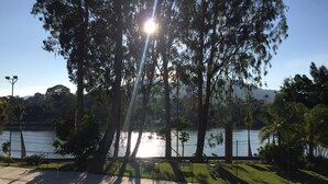 A park with a lake, trees, and a clear sky. - Hotel Itamaracá (Miguel Pereira)