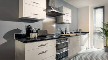 Apartamento ejecutivo | Cocina privada | Microondas, horno, placa de cocina y cafetera o tetera