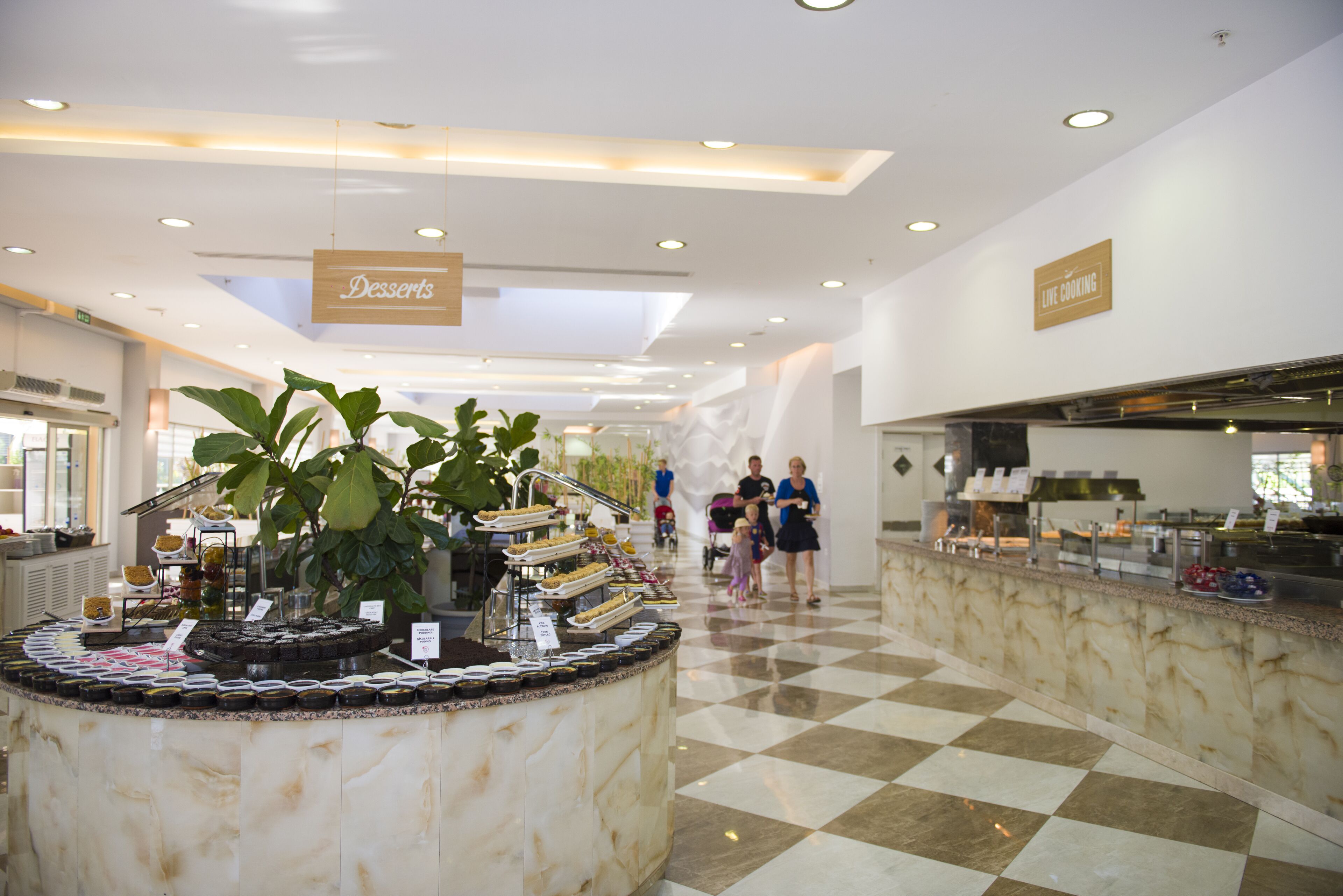 A buffet area with a marble counter and a sign indicating desserts.