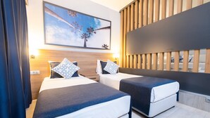 A hotel room with two beds, a large painting, wooden slats, and a nightstand.