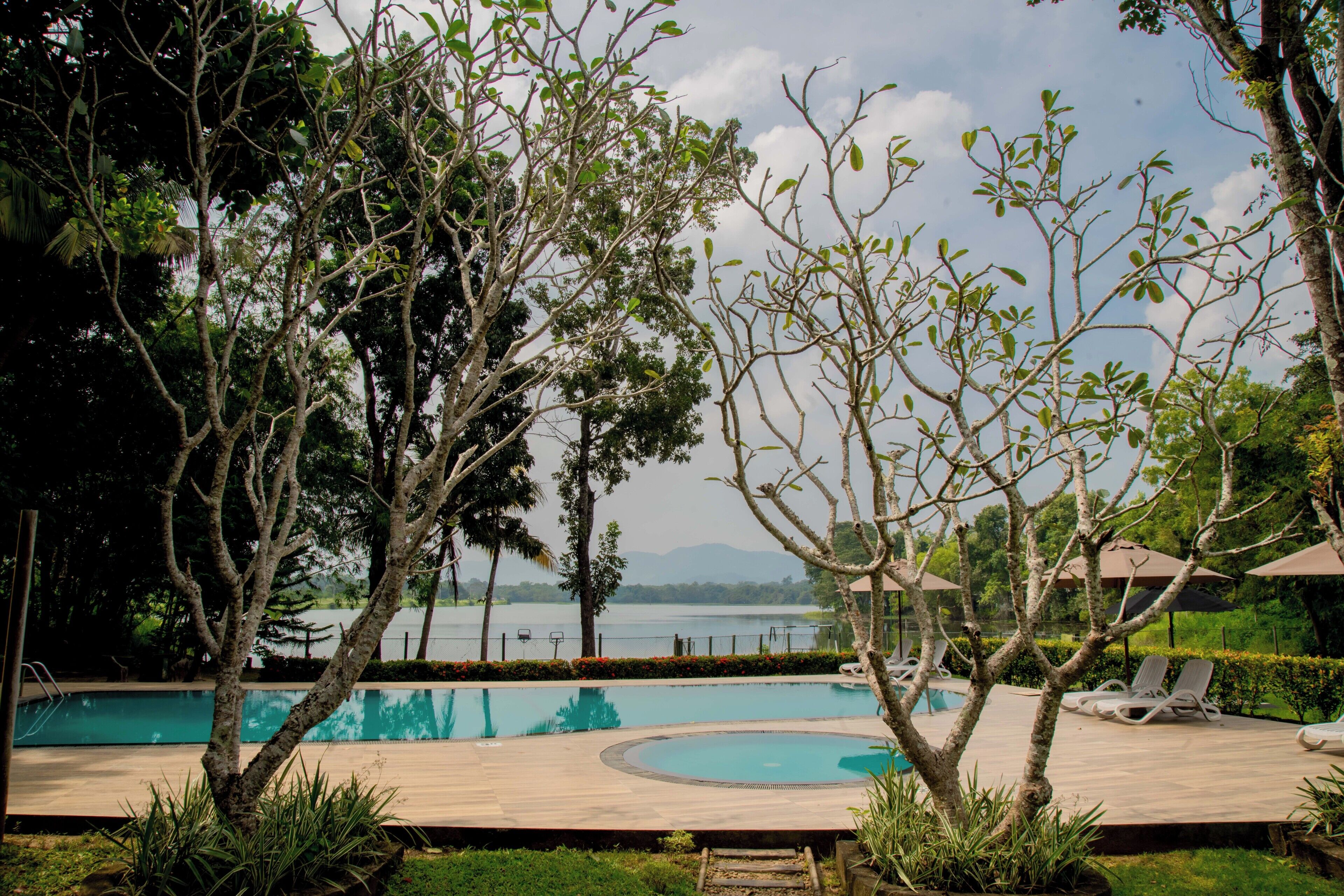 A swimming pool with a view of a lake and mountains in the distance.