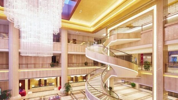 A multi-level atrium with a central spiral staircase, large chandeliers, and multiple balconies. - Huaxi Hotel (Weihai)