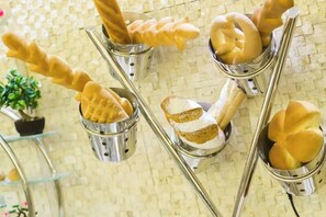 A wall-mounted display of various bread shapes in metal containers.