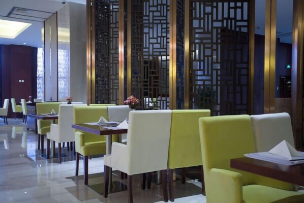 A restaurant with tables and chairs, a decorative wall, and a modern interior design.