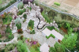 A landscaped garden with stone pathways and various plants.