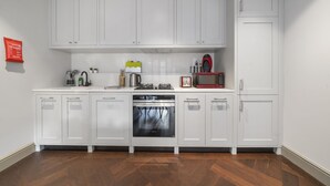 A kitchen with white cabinets, a microwave, a stove, and a dishwasher.