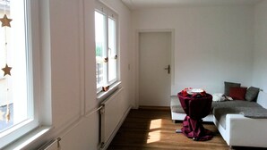 Habitación triple, baño privado | Zona de estar | Una televisión de pantalla plana