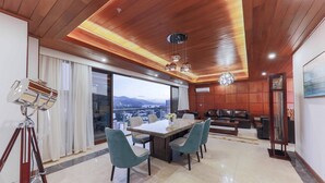 Un comedor moderno con una mesa grande, cuatro sillas y vistas a la ciudad a través de amplias ventanas.