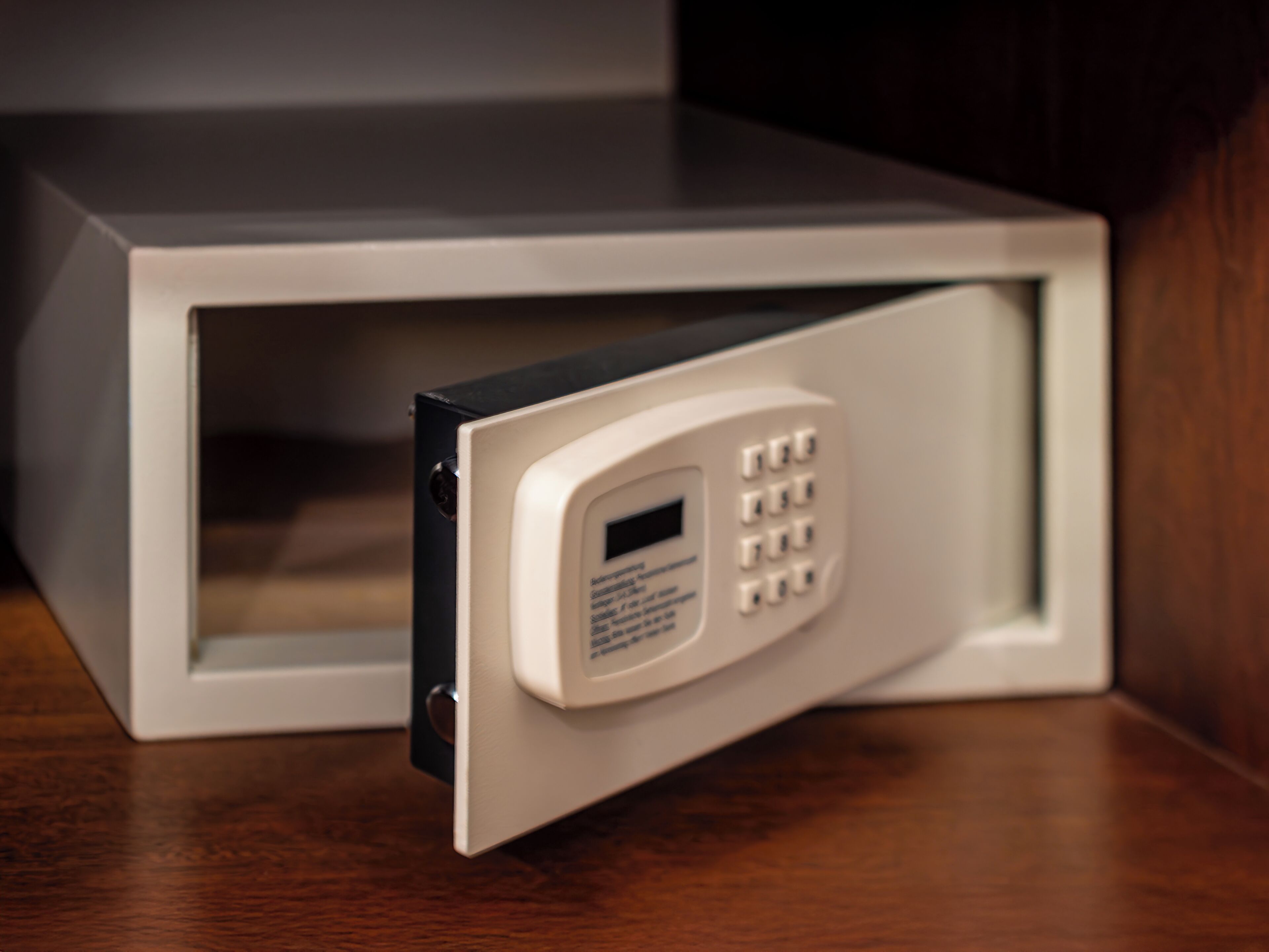 A microwave with a keypad and a digital display, placed on a wooden surface.