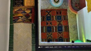 Una habitación con sofá, alfombras estampadas y un adorno en la pared.
