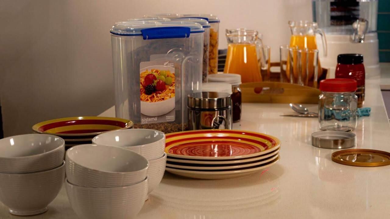 Een ontbijtbuffet met duidelijke bakken, kommen, borden en toevoegingen.