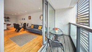 Un appartement moderne doté d’un balcon, d’un coin repas et d’un salon.