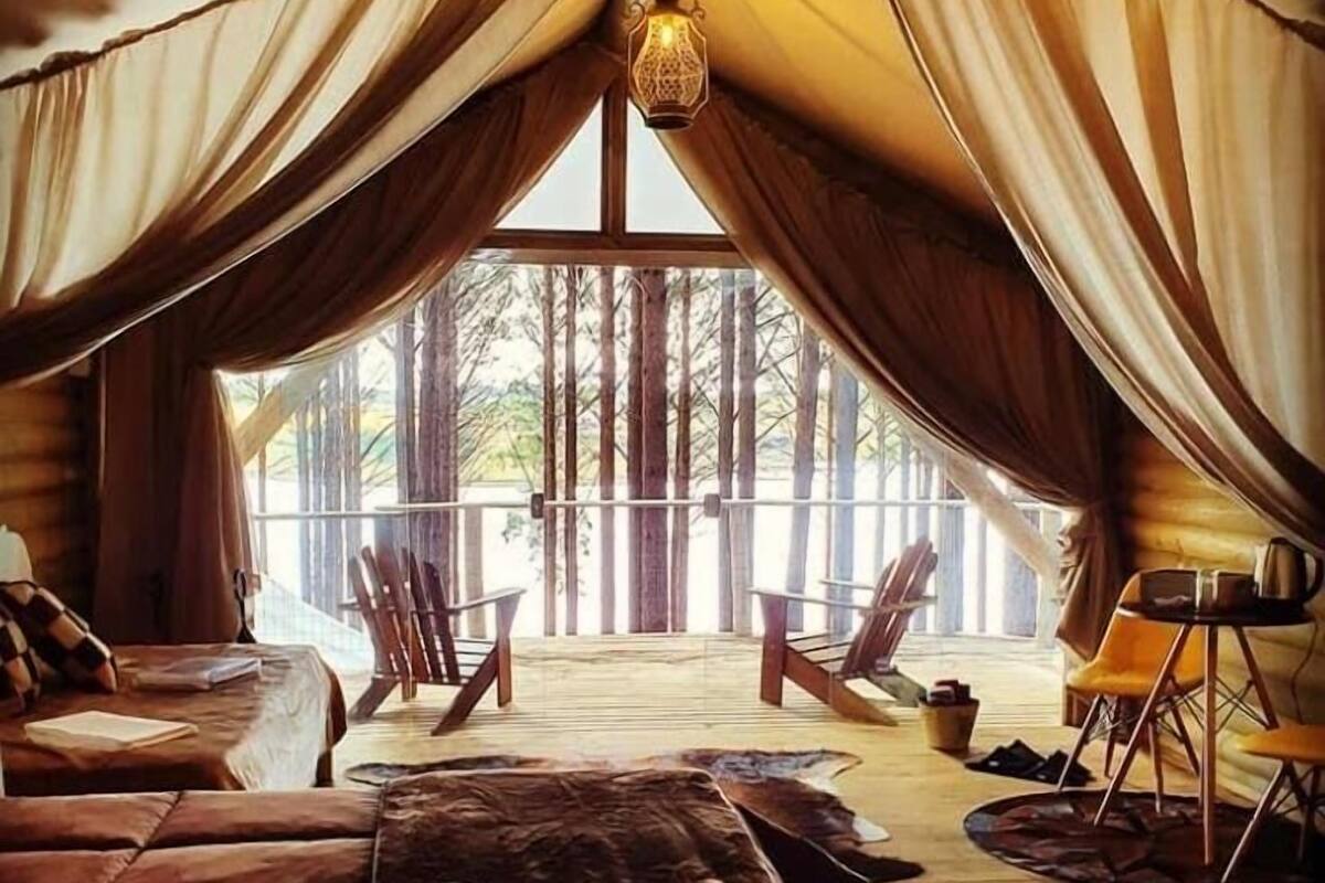 Une pièce confortable avec un grand lit, un coin salon avec des fauteuils et une table à manger.