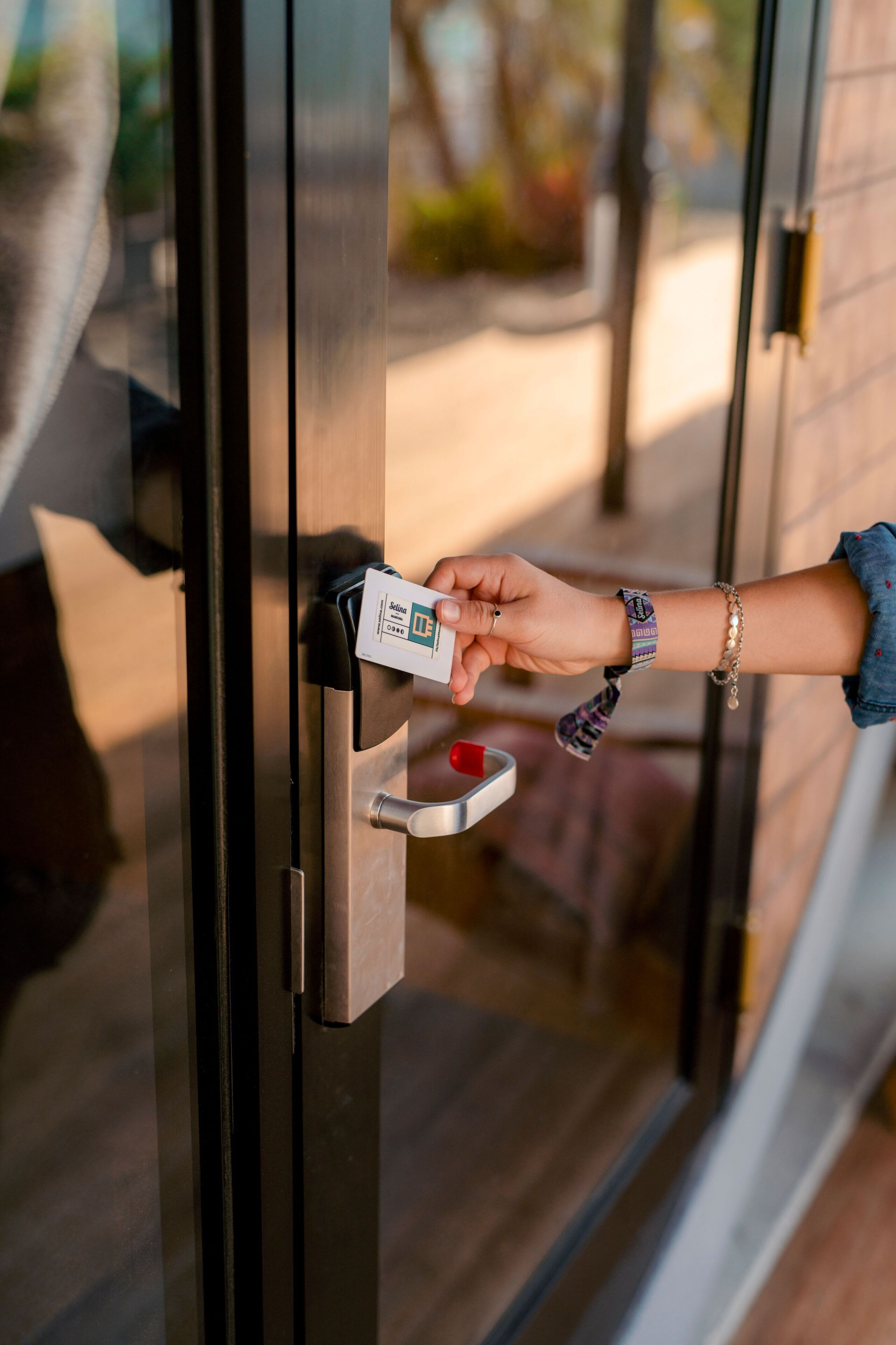 A hand inserting a key into a door lock.