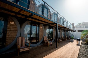 Un edificio moderno con finestre circolari e un'area relax con sedute in legno.