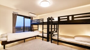 Une chambre avec des lits superposés, une fenêtre avec des rideaux, un appareil de climatisation et un sol recouvert de moquette.