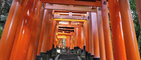 A series of orange torii gates leading up a stone staircase.
