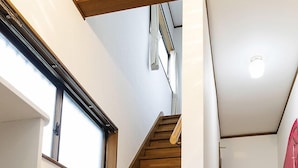 Una escalera de madera en un interior moderno con paredes blancas y suelo de madera.