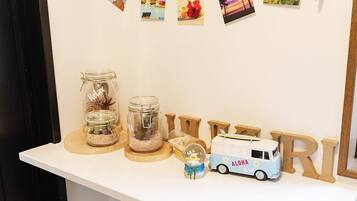 A shelf with jars, a toy bus, and wooden letters spelling "ALPHA RELAX".