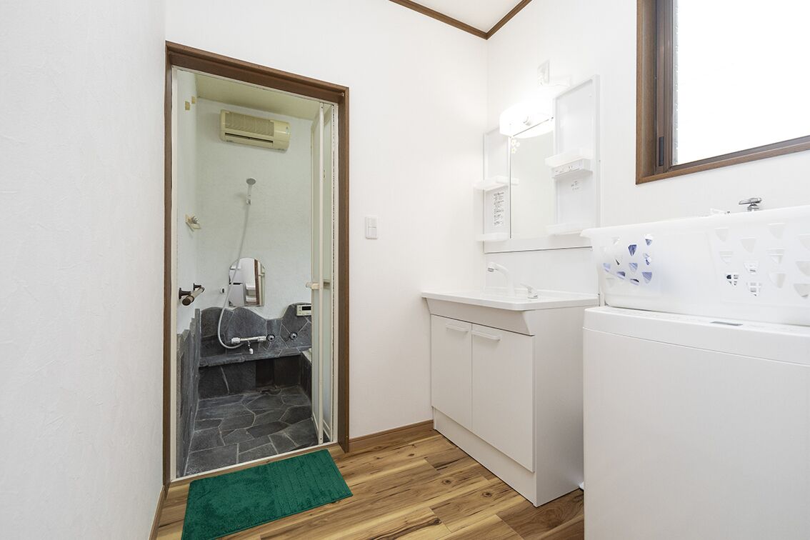 A bathroom with a shower, a toilet, a sink, and a mirror.
