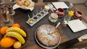 A breakfast table with croissants, fruit, jam, and a cake. - 50 Route du Gourdon (Cénac-et-Saint-Julien)