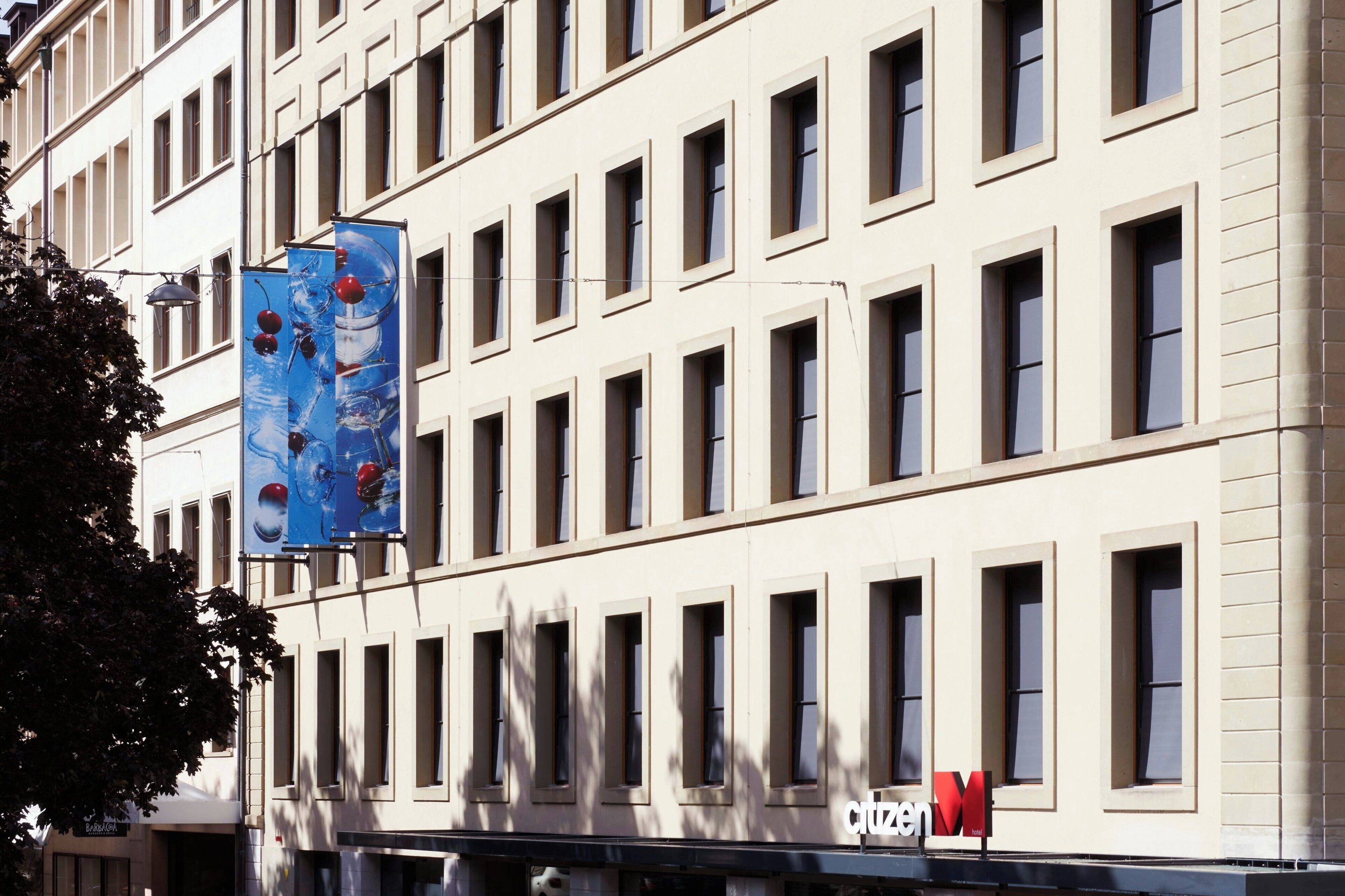 Un edificio de varios pisos con una fila de ventanas y una señal visible de 'citizenM'.