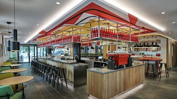 A modern bar area with a central counter, multiple stools, and a variety of bar tools and bottles.