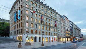 A historic building with multiple shops on the ground floor, including 'Aeschbach' and 'Citizen'. - citizenM Geneva (Geneva)
