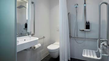 Ein modernes Badezimmer mit Waschbecken, Toilette und Duschbereich in Weiß.