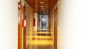 A corridor with wooden ceiling, white walls, and a shiny floor. - Swamy Hotel (Cruzeiro do Sul)