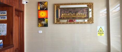 Una habitación de hotel con una puerta de madera, un cuadro colgado en la pared, una obra de arte enmarco y un letrero de precaución.