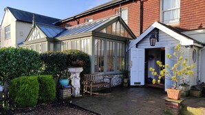 A traditional house with a conservatory, a stone bench, and a gravel pathway. - The Arundel Park Hotel (Arundel)