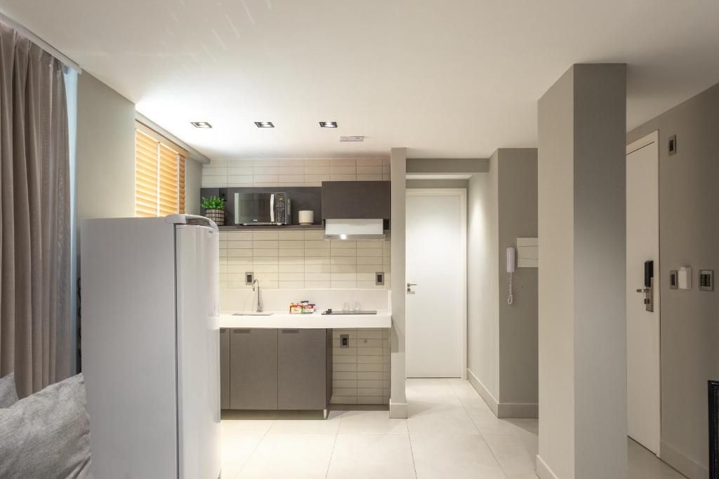 A modern kitchen with a refrigerator, microwave, and cabinets.