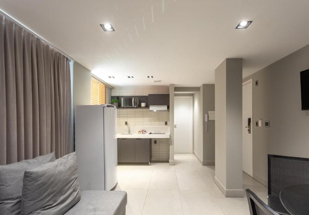 Un interior moderno con sofá, mesa de comedor y zona de cocina.