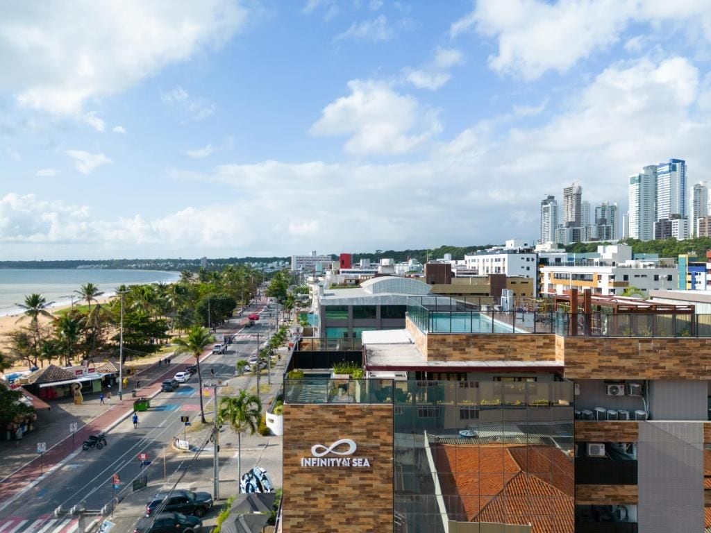 A coastal cityscape with modern buildings, a beach, and a clear sky.