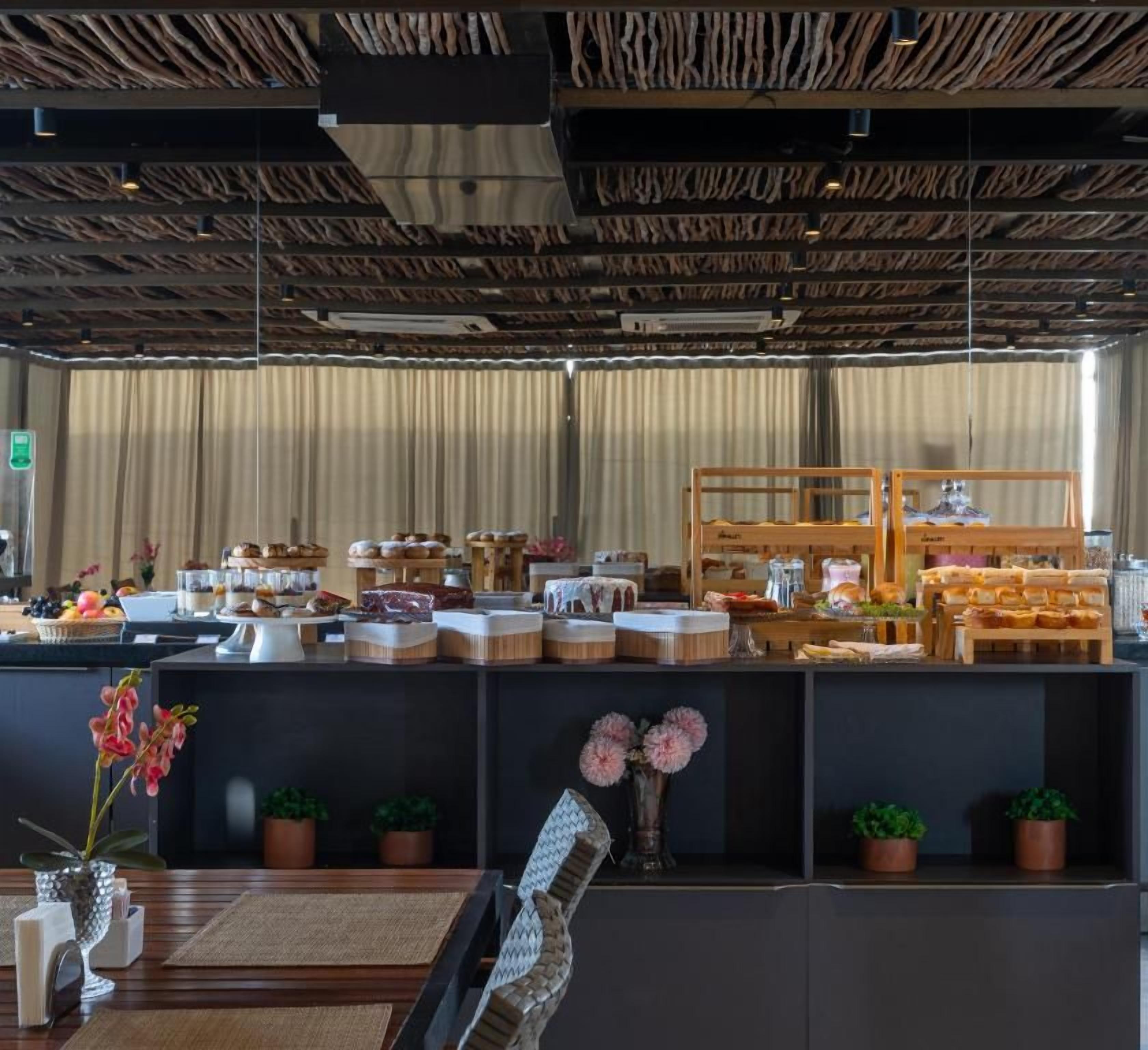 A breakfast buffet with various food items and a wooden display counter.