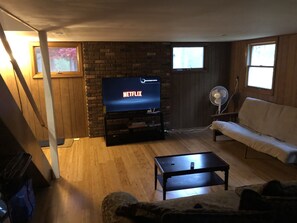 Relax in this inviting living room with a brick accent wall, comfortable sofa, and flat-screen TV.