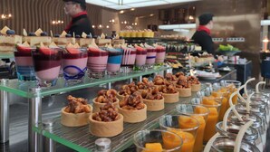 A dessert display with various colorful parfaits and nut-topped tarts. - Novotel Zhengzhou Airport (Zhengzhou)