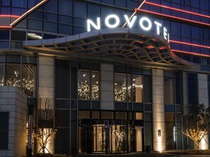 A modern hotel entrance with a prominent 'NOVOTE' sign, large glass windows, and a well-lit facade. - Novotel Zhengzhou Airport (Zhengzhou)