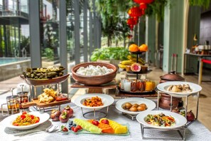 Enjoy a diverse buffet spread featuring Asian cuisine, fresh fruits, and a variety of dishes.