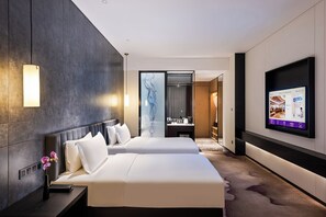 A hotel room with two beds, a TV, a mirror, and a bathroom visible through a glass door. - Shenzhen Longgang Kunyi Mercure Hotel (Shenzhen)