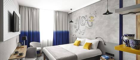 Una habitación de hotel moderna con una cama grande, un escritorio, una silla y un televisor.