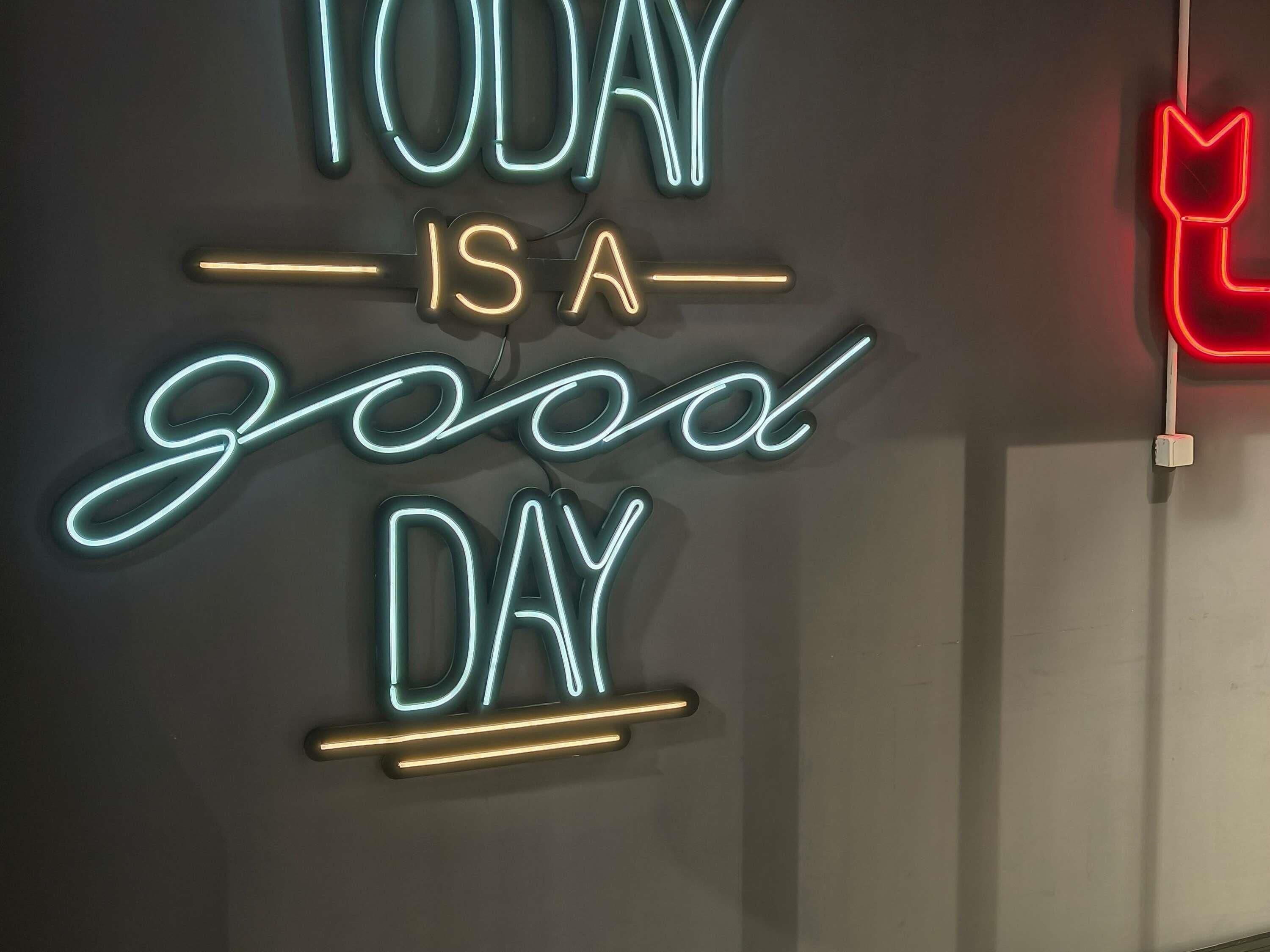 A neon sign with the text 'TODAY IS A good DAY' on a wall.