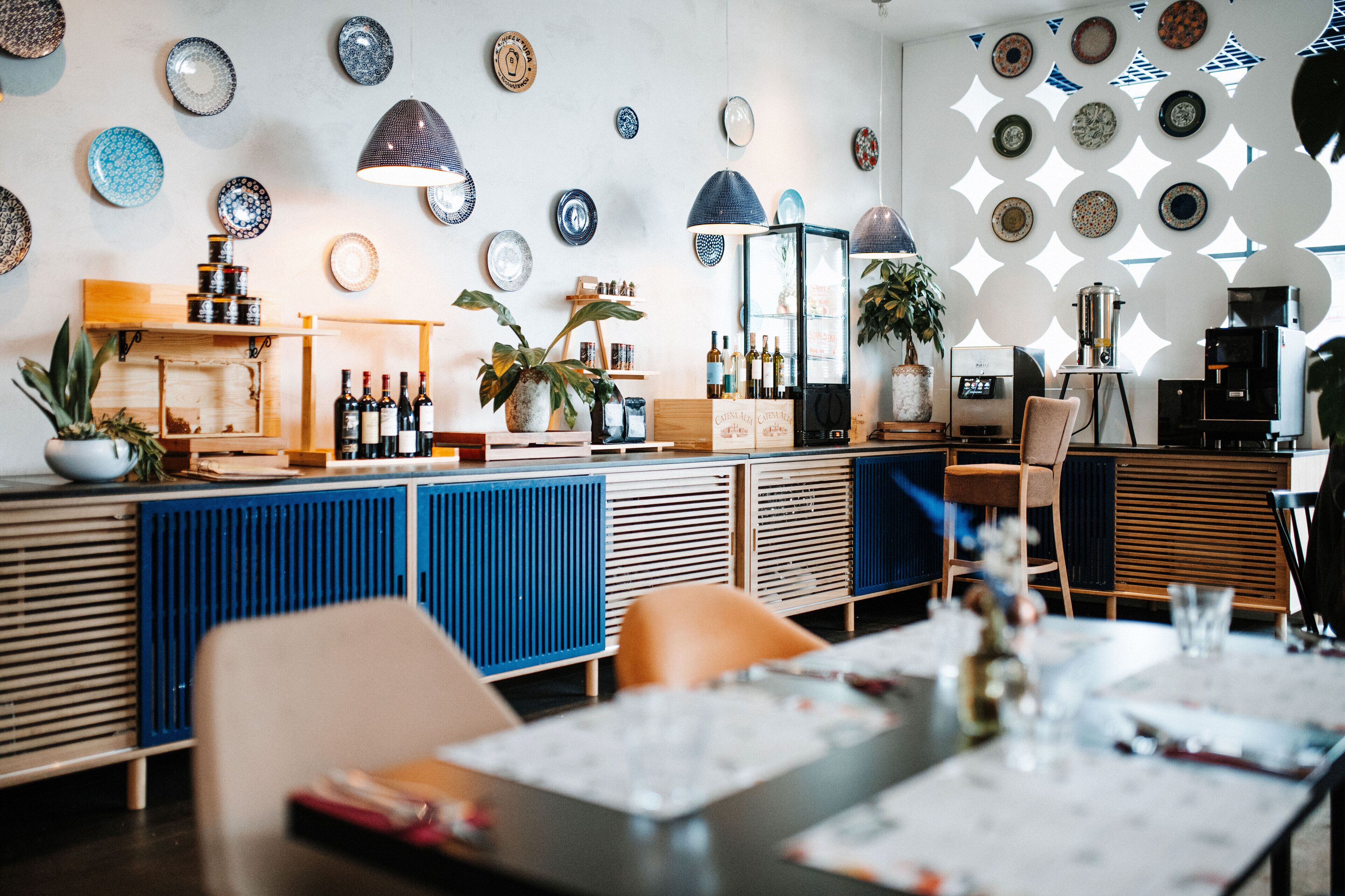 A restaurant interior with a bar area, seating, and decorative plates on the walls.