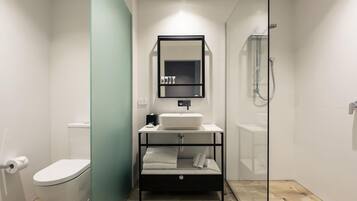 A modern bathroom with a toilet, sink, and shower.
