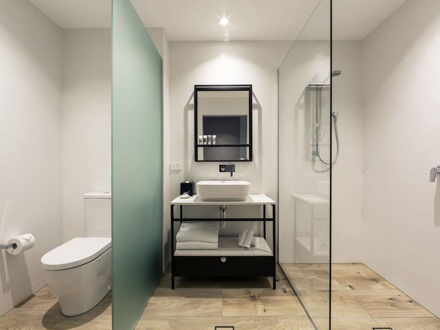 A modern bathroom with a toilet, sink, and shower.