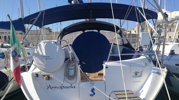 A boat named 'Annapaola' docked at a marina with a covered deck, safety ring, and a flag. - Boat & Breakfast Leporello (Bisceglie)