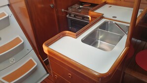A compact kitchen with a sink, stove, and storage cabinets. - Boat & Breakfast Leporello (Bisceglie)