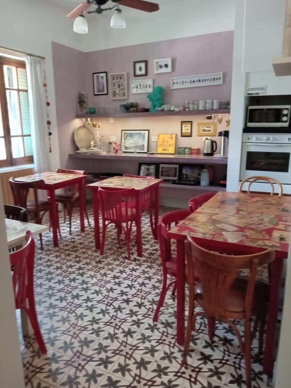 A dining area with a patterned floor, red chairs, and a table with a tablecloth.